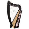 A harp-shaped acoustic guitar with a black wooden frame, natural wood soundboard, and pink cherry blossom floral decoration on the side, shown against a plain white background.